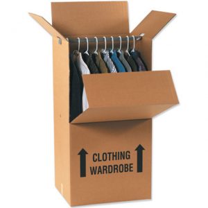 A cardboard box labelled ‘Clothing Wardrobe’ with an open top, containing clothes hanging on a metal rail.